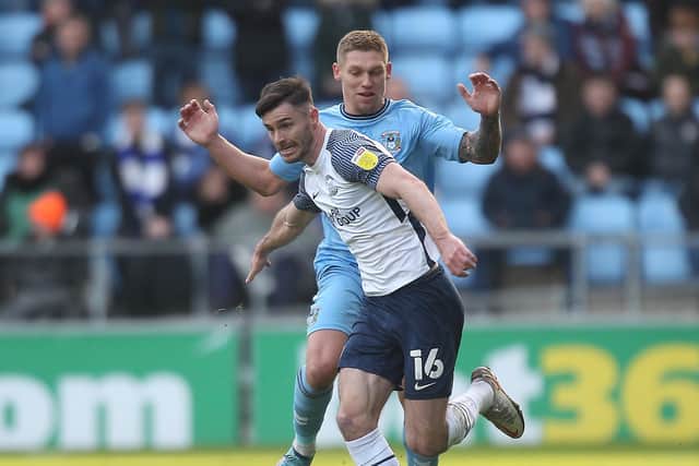 Preston North End defender Andrew Hughes holds off Coventry's Martyn Waghorn