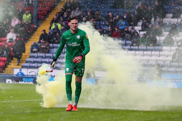 Preston North End's Freddie Woodman removes a flare from the pitch.