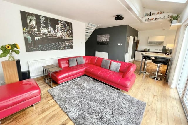 The living room at the back of the house opens up to the kitchen. It has solid walnut flooring and three Velux windows. It overlooks the garden