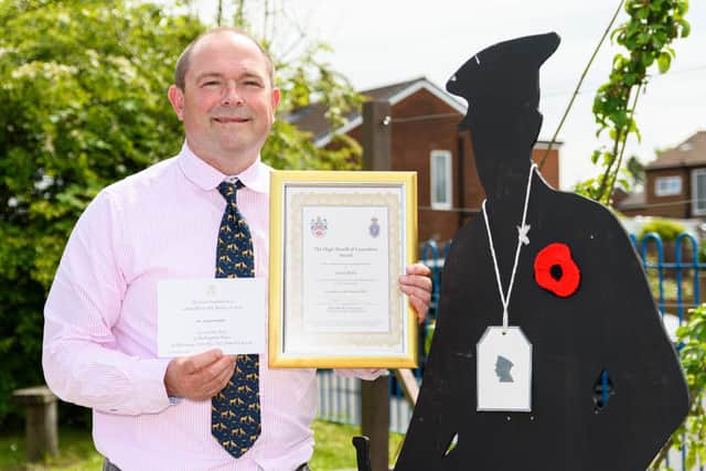 Simon Wallis pictured with his invite to Buckingham Palace, his High Sheriff of Lancashire award certificate, and props from 'Armistice - The Great War Remembered', which he wrote.