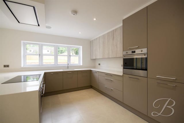 Our first port of call is the modern kitchen, which comes complete with stylish cabinets and units, and a quartz work surface. Integrated appliances abound, and there is even a built-in radio