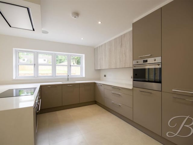 Our first port of call is the modern kitchen, which comes complete with stylish cabinets and units, and a quartz work surface. Integrated appliances abound, and there is even a built-in radio