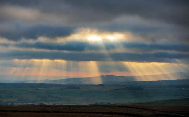Crepuscular rays shine down on the Forest of Bowland from the moors above Settle
