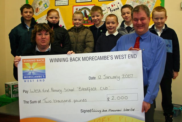 Janice Hanson presenting a cheque to head teacher Steve Wetherall, with members of the Morecambe West End breakfast club