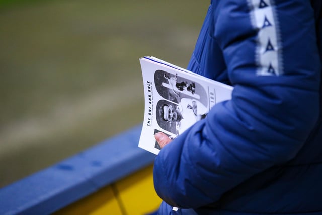 A Preston North End fan holds a programme remembering Sir Tom Finney