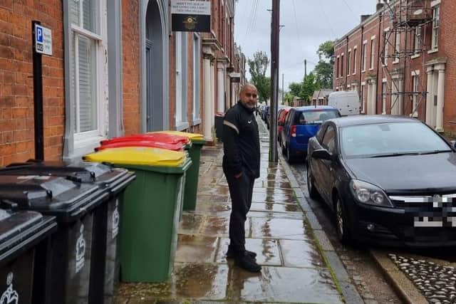 Mohamed Vaid pictured next to bins left out in Avenham.