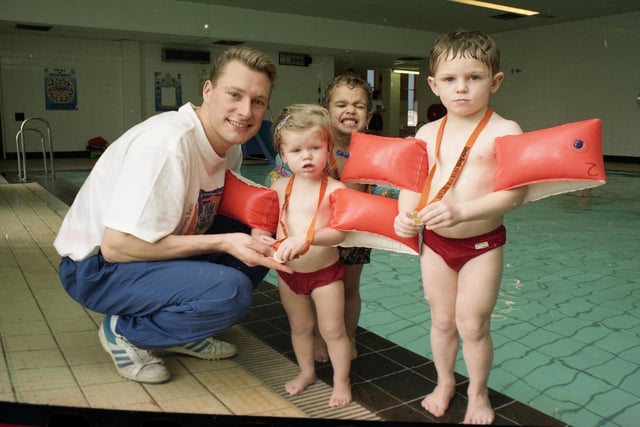 More than 600 Preston swimmers took the plunge to raise cash for the Olympics. Swimmers young and old waded in to make more than £6,000 for the British Olympic Association. Picture shows Olympic silver medalist Nick Gillingham giving medals to three young swimmers. From left are Mairi McGilverary, two, Jason Watson, three, and Hugh McGilveray, four