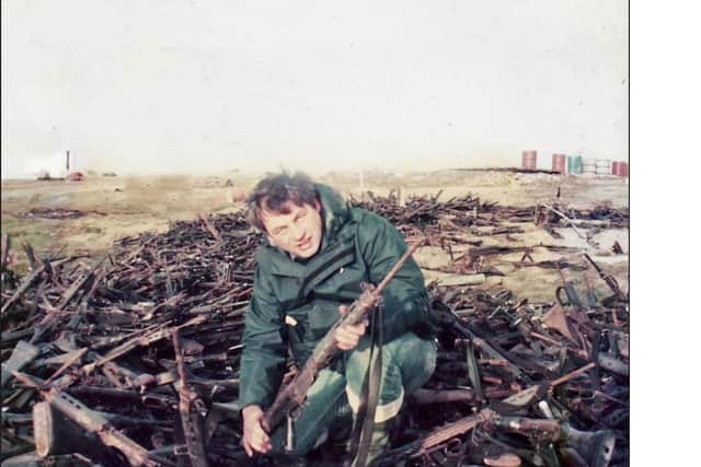 Roger with a pile of captured Argentine weapons.