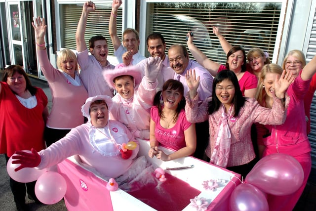 Jackie Nutter sitting in a bath of pink jelly encouraged by staff at Delta Care, Preston - all in aid of charity