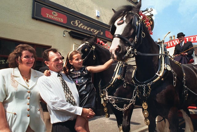 The landlord and landlady of Stacey's Vic with their daughter Stacey (whom the pub is called after) meeting some visiting Shire horses in 1997
