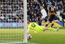 Preston North End's Tom Cannon scores his side's second goal despite the attentions of Wigan Athletic's Charlie Hughes, beating Ben Amos at his far post