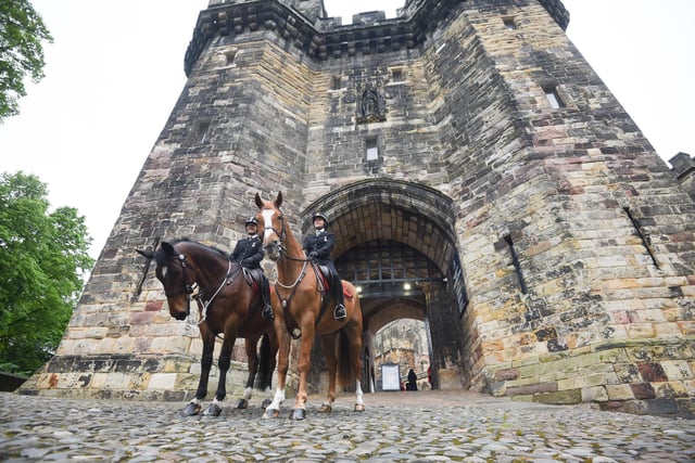 Police horses guard the entrance to Lancaster Castle.