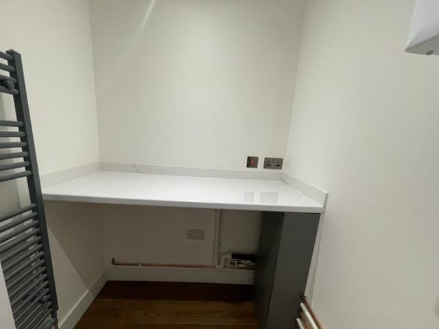 A handy utility room boasts a wall-mounted boiler and plumbing for an automatic washing machine.