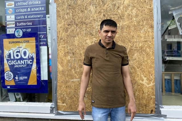 Newsagent Mustak Chhadat pictured outside the boarded up window of his business on Berry Lane