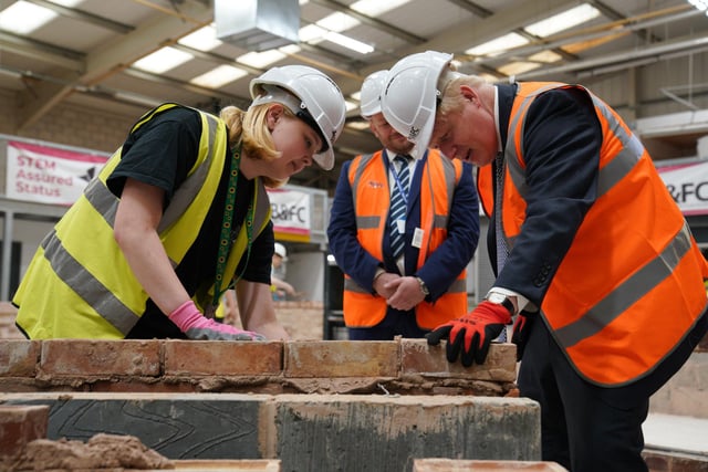 Prime Minister Boris Johnson takes part in a brick laying lesson