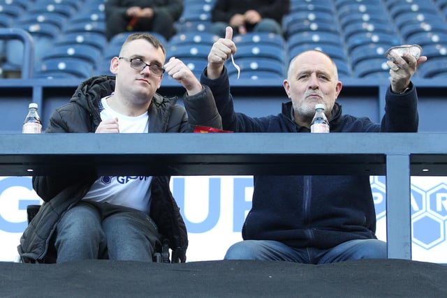 Inside the ground, two North End fans give a thumbs up to our photographer. whilst also enjoying a pie.