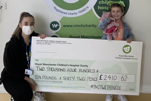 Indie handing over the cheque to the Royal Manchester Children's Hospital