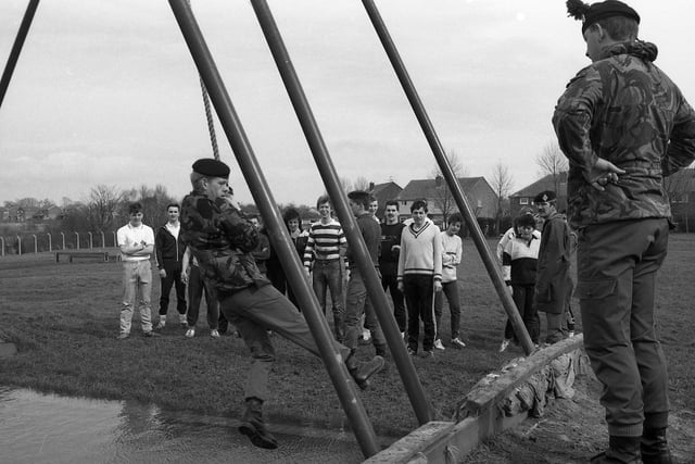 More than 20 staff from Morrison's in the Guild Hall Arcade look on as soldiers show them how to cross the rope obstacle on the army assault course at Fulwood Barracks. They took part in the gruelling task in order to raise money for the National Children's Home.