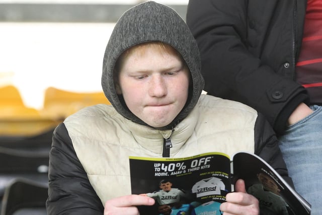 A PNE fan reads the matchday programme at Derby