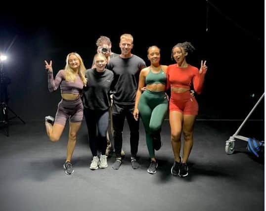 Owner and director of online gymwear clothing Pursue Fitness Michael Hughes, 29, pictured with some of the sportswear models
