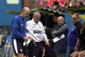 Mick Rathbone helps Paul McKenna off the pitch during his time as Preston North End physio