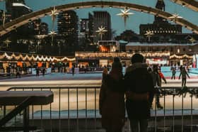 Couple standing by a city ice rink