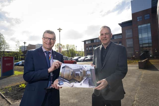 UCLan's Professor Graham Baldwin and Morgan Sindall's Richard Potts. They are holding up a picture of the planned new building in front of the current building.