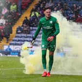 Preston North End's Freddie Woodman removes a flare from the pitch