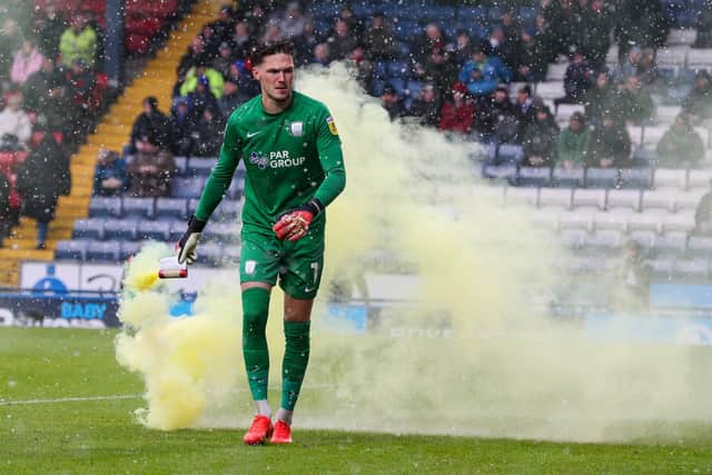 Preston North End's Freddie Woodman removes a flare from the pitch