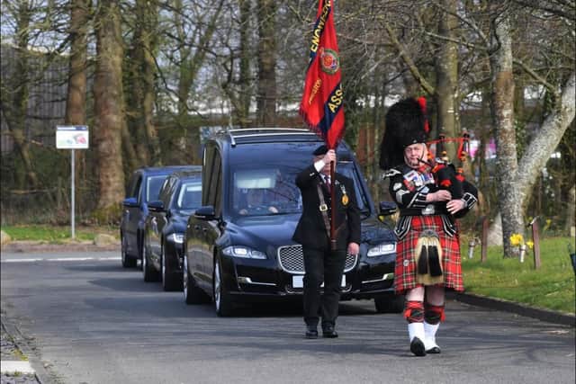 A piper leads the funeral cortege of Major Philip Kenyon.