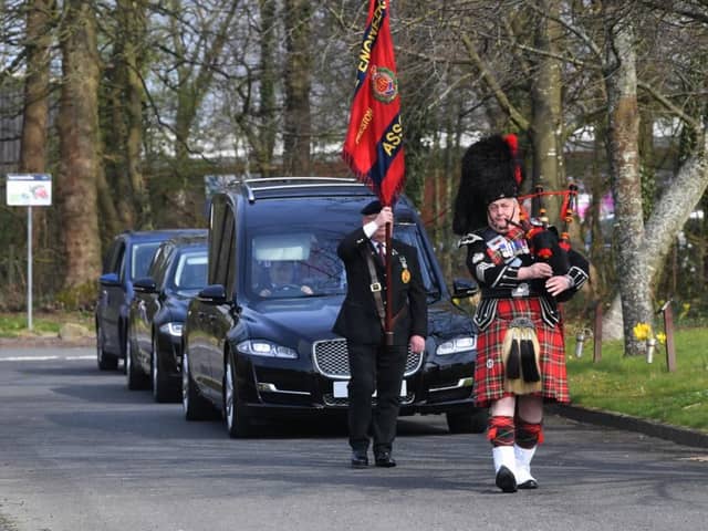 A piper leads the funeral cortege of Major Philip Kenyon.
