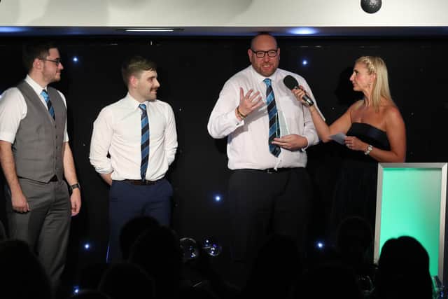 Typhoons RUFC members on stage, with chairperson Chris Goulding talking to event host Fiona Sadler