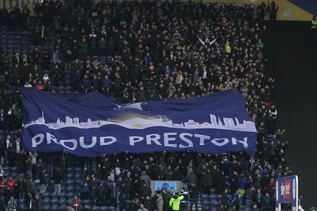 Preston North End fans pass a surfer flag above their heads in the Bill Shankly Kop