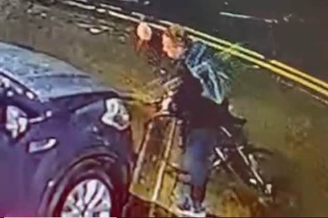 Brooklands Motor Company have offered a cash reward after this man was caught vandalising a car. Above he is pictured holding what appears to be a hammer.