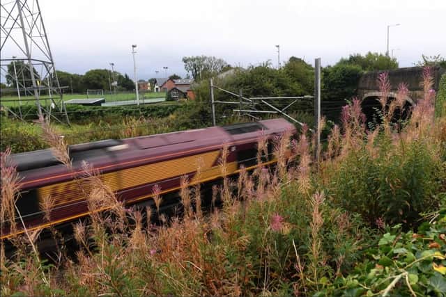 A train whistles past on the West Coast Main Line, just yards from the village hall.