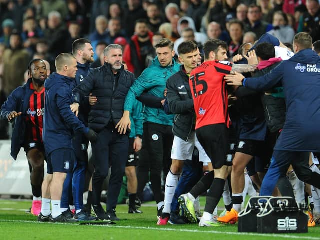 Ryan Lowe is pulled away while tempers flare at the end of PNE's defeat against Swansea