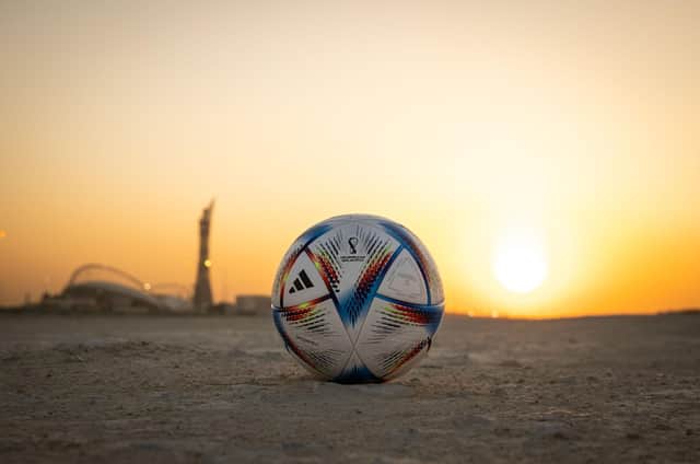DOHA, QATAR - NOVEMBER 16: In this photo illustration,  the Official Match Ball of FIFA World Cup Qatar 2022 is seen in front of Khalifa International Stadium at sunset ahead of the FIFA World Cup Qatar 2022 on November 16, 2022 in Doha, Qatar. (Photo by Ryan Pierse/Getty Images)