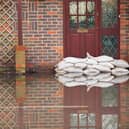 Sandbags outside front door of flooded house. Photo: Adobe