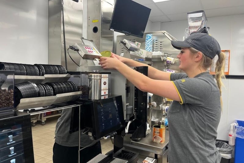 A staff member works the coffee machine