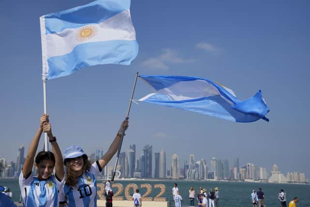 Two Argentina's soccer fans hold their country's flag on the eve of the World Cup group C soccer match between Argentina and Saudi Arabia, in Doha
