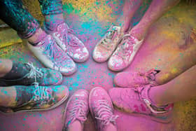 The colorful shoes and legs of teenagers at color run event.