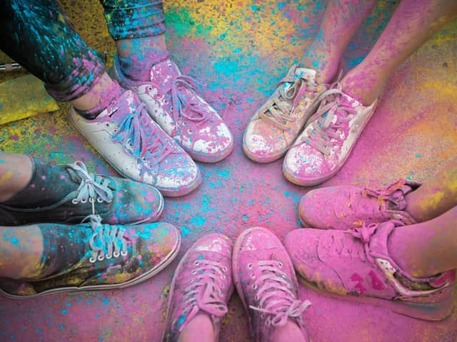 The colorful shoes and legs of teenagers at color run event.
