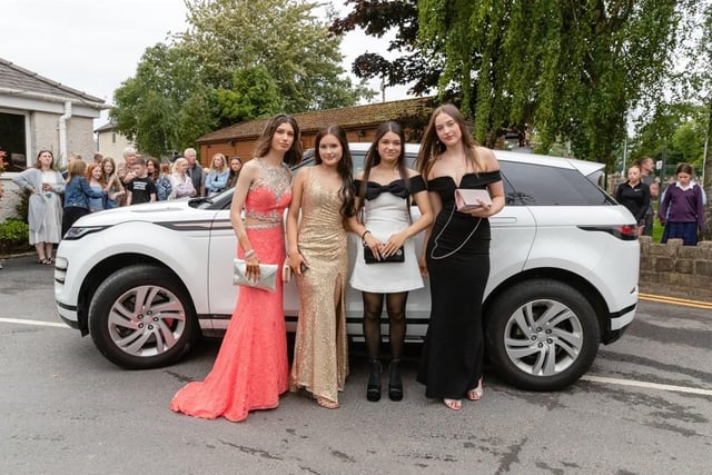 A group of friends pose outside a car