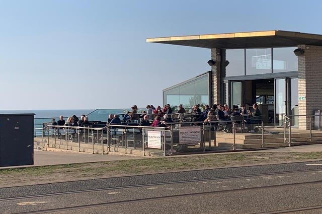 Folks enjoying the sun at the Beach House with views over Blackpool's sun-splashed Promenade