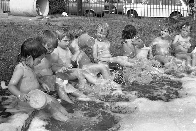 Bath time was never like this... and what a sneaky way these grown-ups have of keeping us clean! Children of the Hartington Road Day Nursery, Preston, don't know anything about centigrade and fahrenheit but they reckon that clothes are just a waste of time when the sun is beating down and there's a paddling pool outside. But never mind the heatwave... This image was taken in 1973