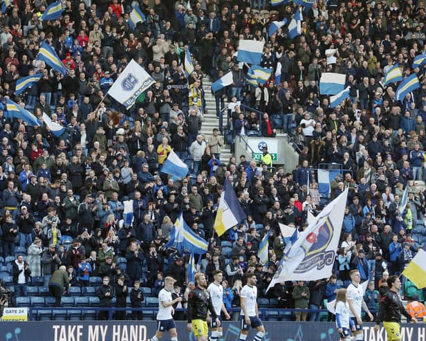 Preston North End fans wave banners and flags as they welcome their side onto the pitch ahead of kick-off