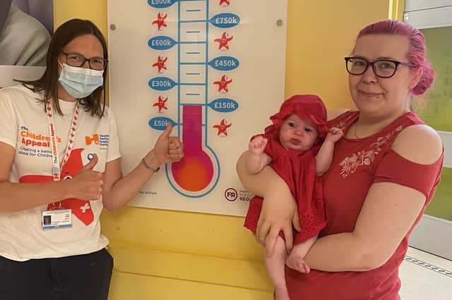 Baby Clara Bentley with mum Sophie William watch watch appeal fundraiser Lucy Clark (left) raise the Children’s Appeal barometer bar to £150,000.