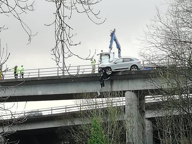 Pictures from the scene show a white car was left hanging off the carriageway