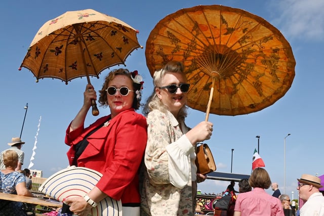 Two ladies dressed up with parasols for the annual free family festival, Vintage by the Sea in Morecambe.