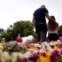Members of the public lay and look at floral tribute left outside the Town Hall in Southport, ahead of a vigil, in memory of three children who died in a "ferocious" knife attack during a Taylor Swift event at a dance school last Monday. Picture date: Monday August 5, 2024.
